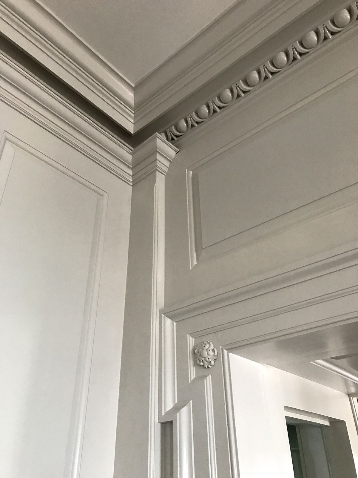 A close up of a door with a molding on the ceiling.