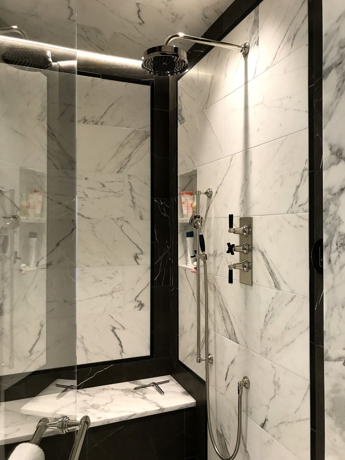 A bathroom with a shower head and a mirror.