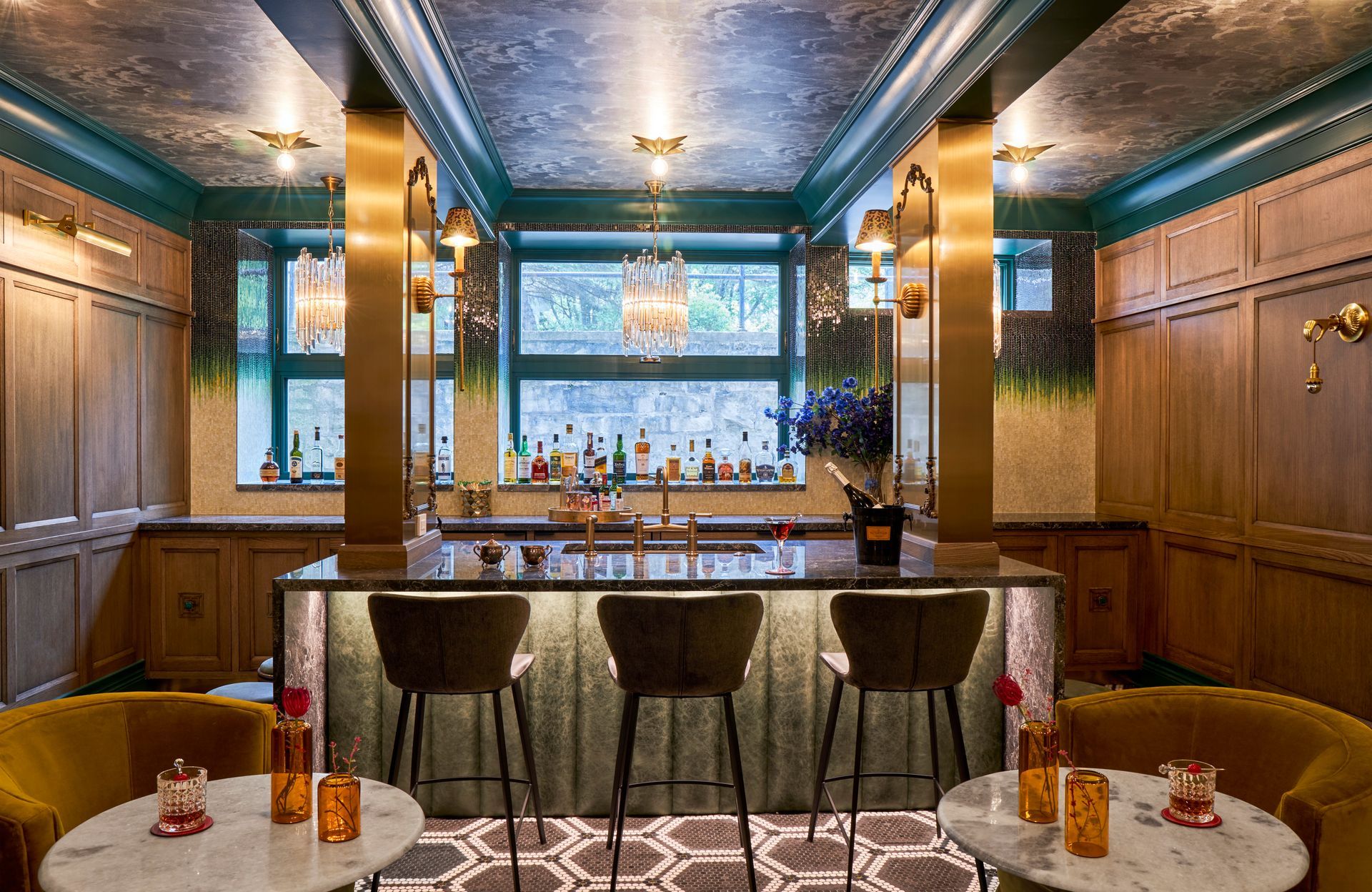 There is a bar in the middle of the room with tables and chairs.