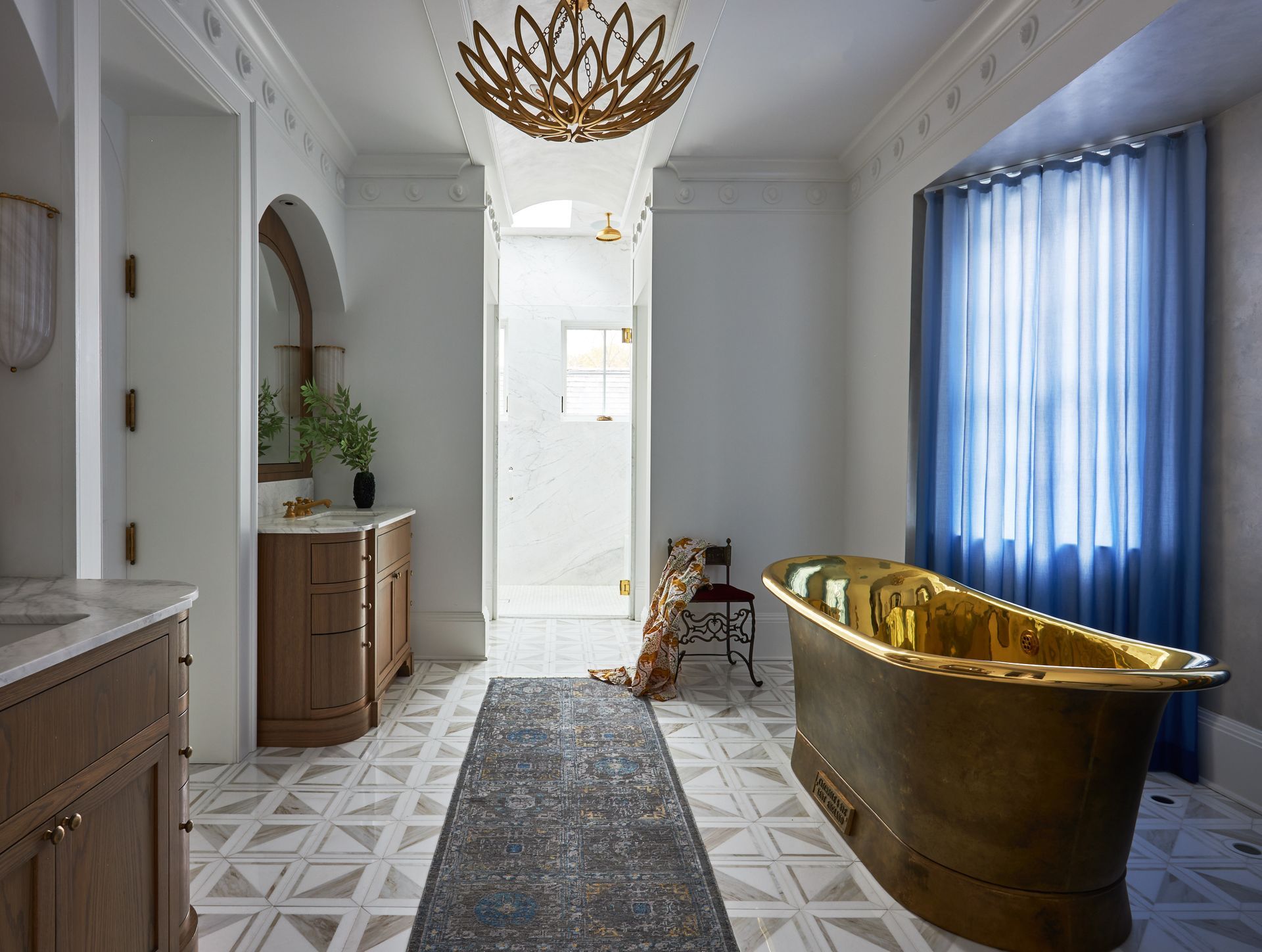 A bathroom with a gold bathtub and blue curtains