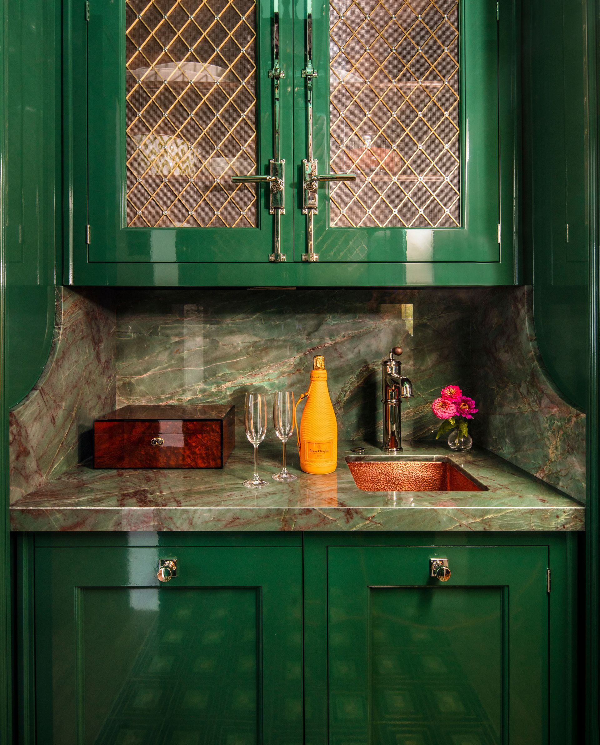 A kitchen with green cabinets and a sink.