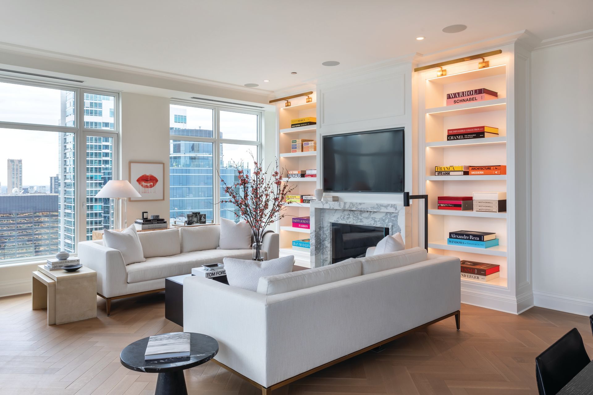 A living room with a white couch, fireplace, and television.