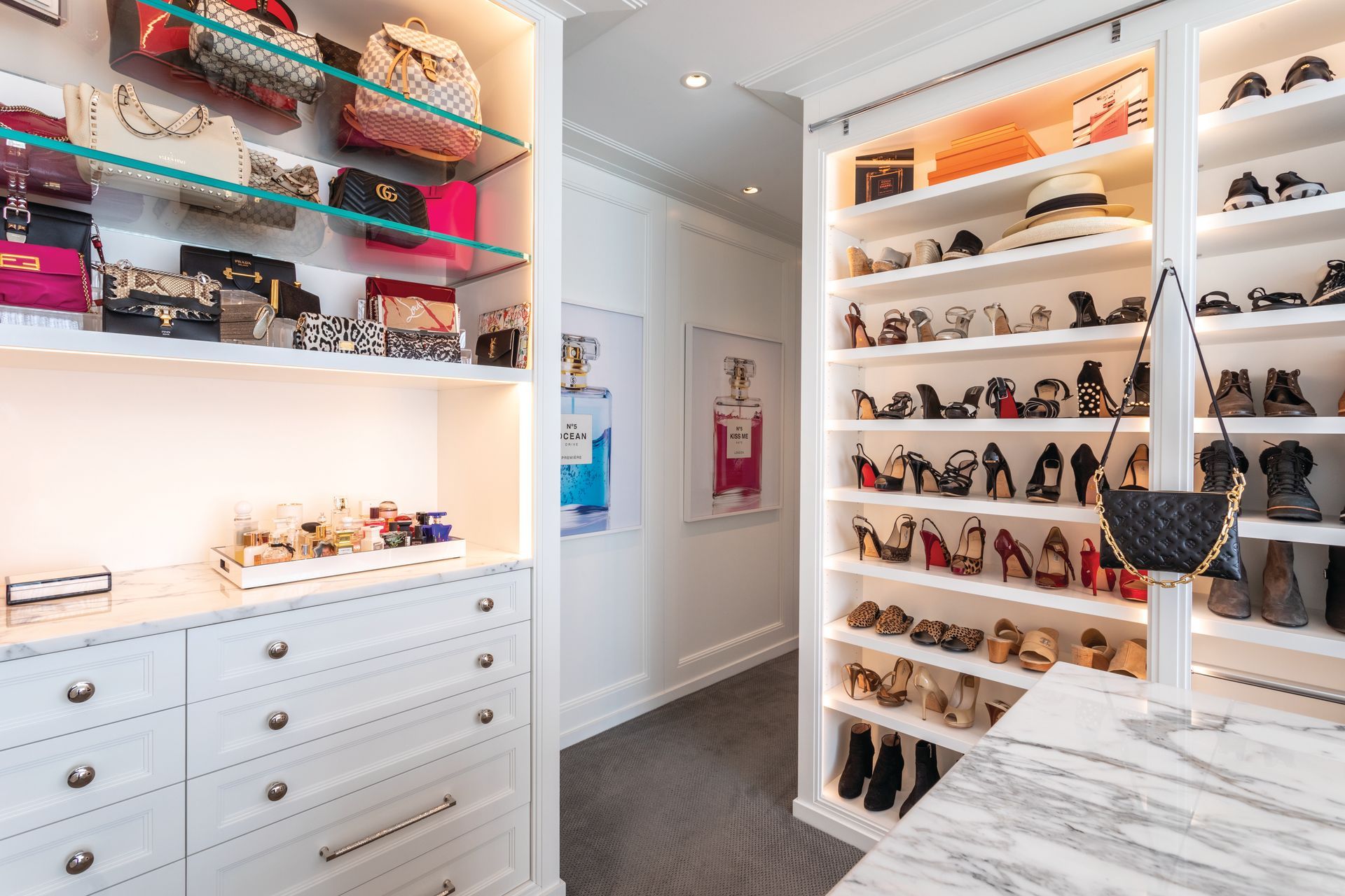 A walk-in closet filled with lots of shoes and handbags.