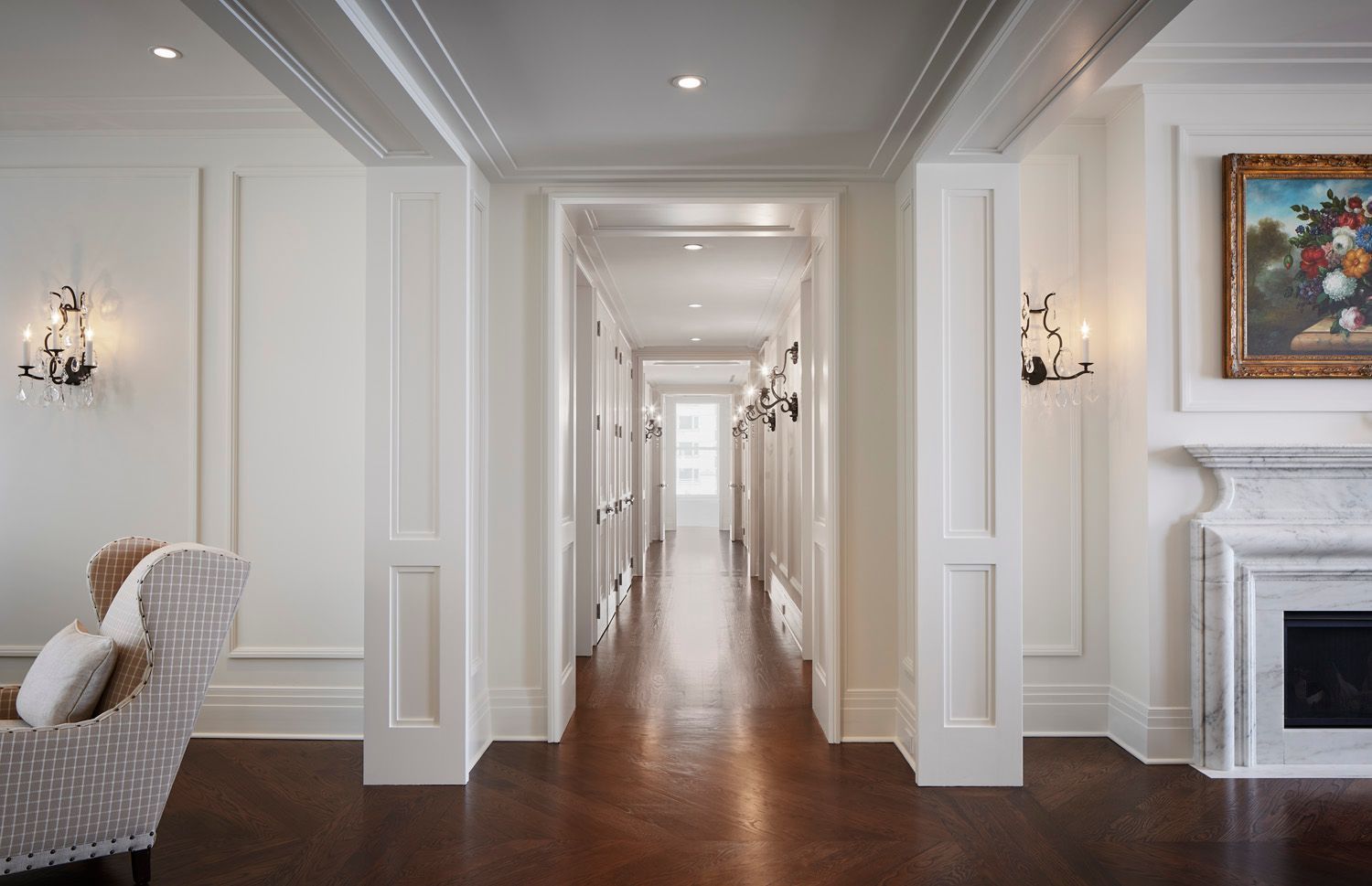 A long hallway in a house with a fireplace and a painting on the wall.