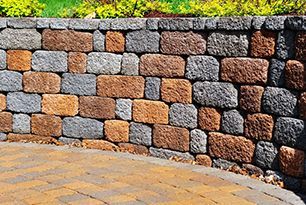 A brick retaining wall with a brick walkway in front of it