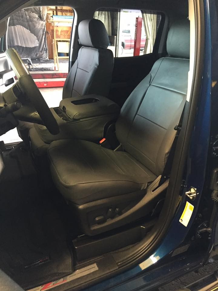 Blue truck interior with black leather seats and center console.