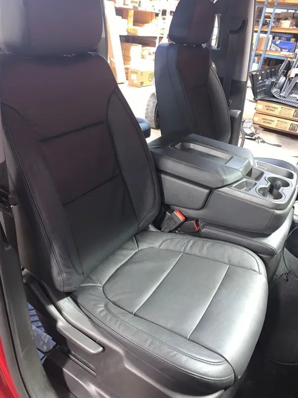Black leather truck seat with center console, in a red truck interior.