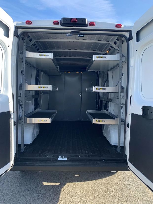 Open cargo van interior with shelving and pull-out drawers.