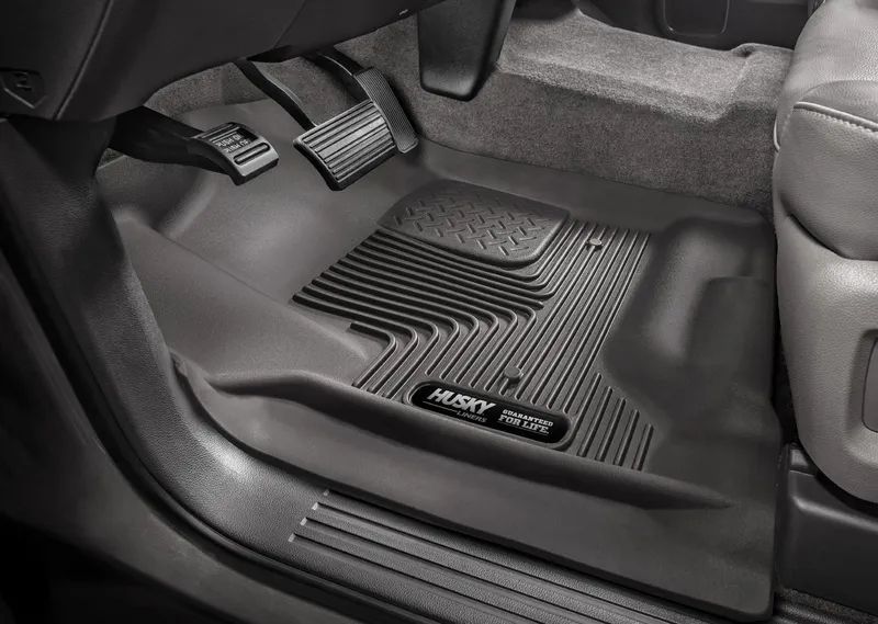 Black Husky Liner floor mat inside a car, covering the footwell and pedals.