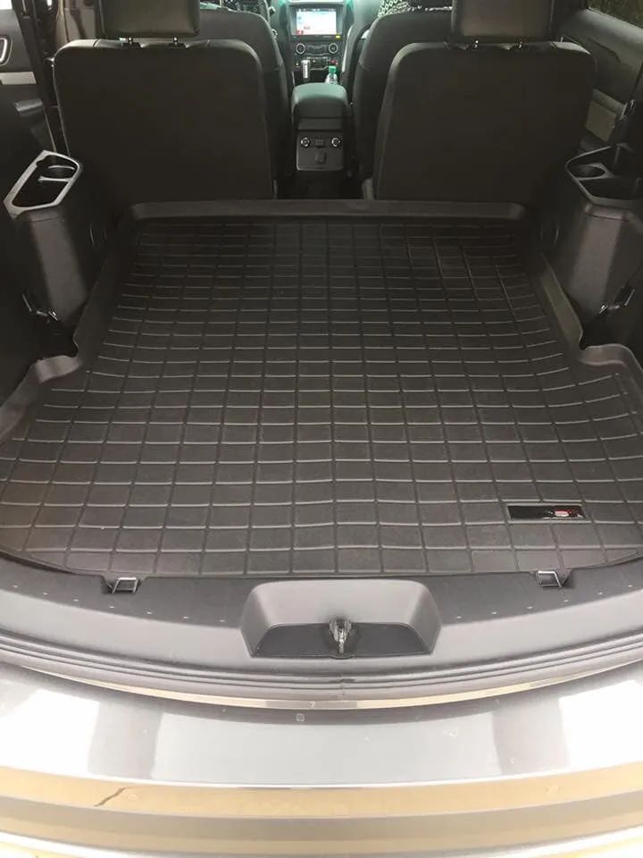 Black rubber cargo liner in the back of a car, covering the floor.