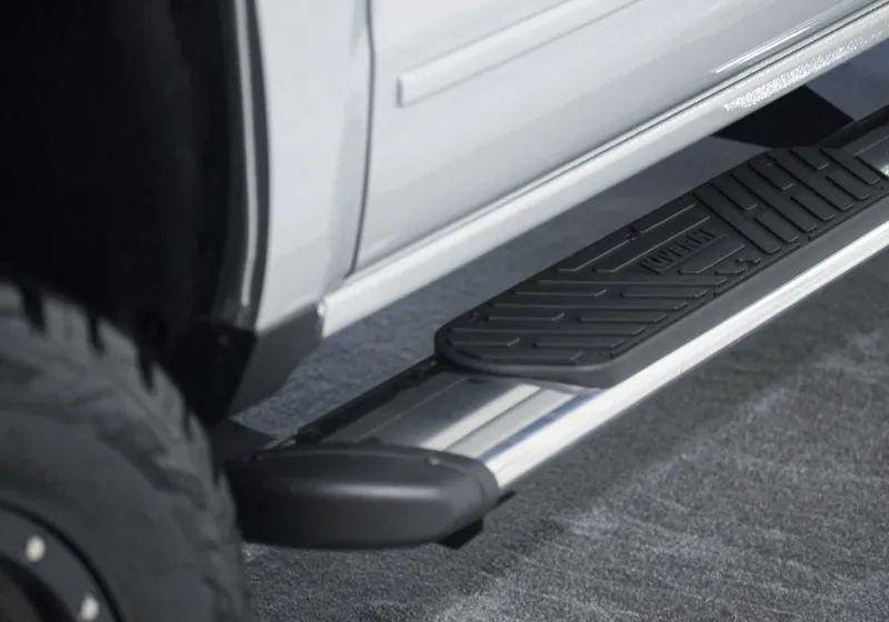 White truck with a silver running board and black step pad.