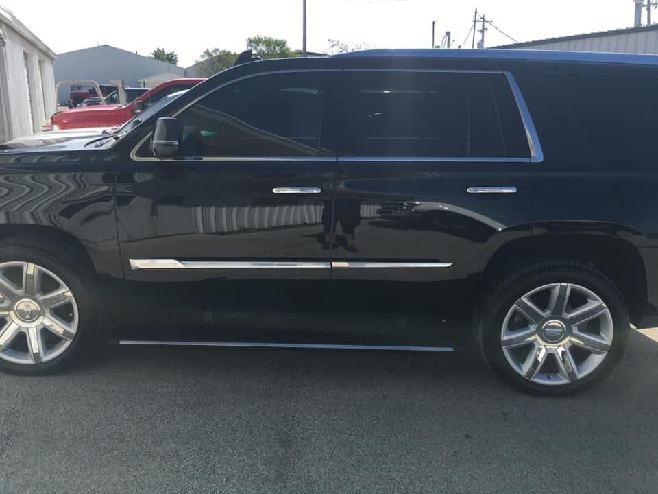 Black Cadillac SUV with chrome accents parked on asphalt.