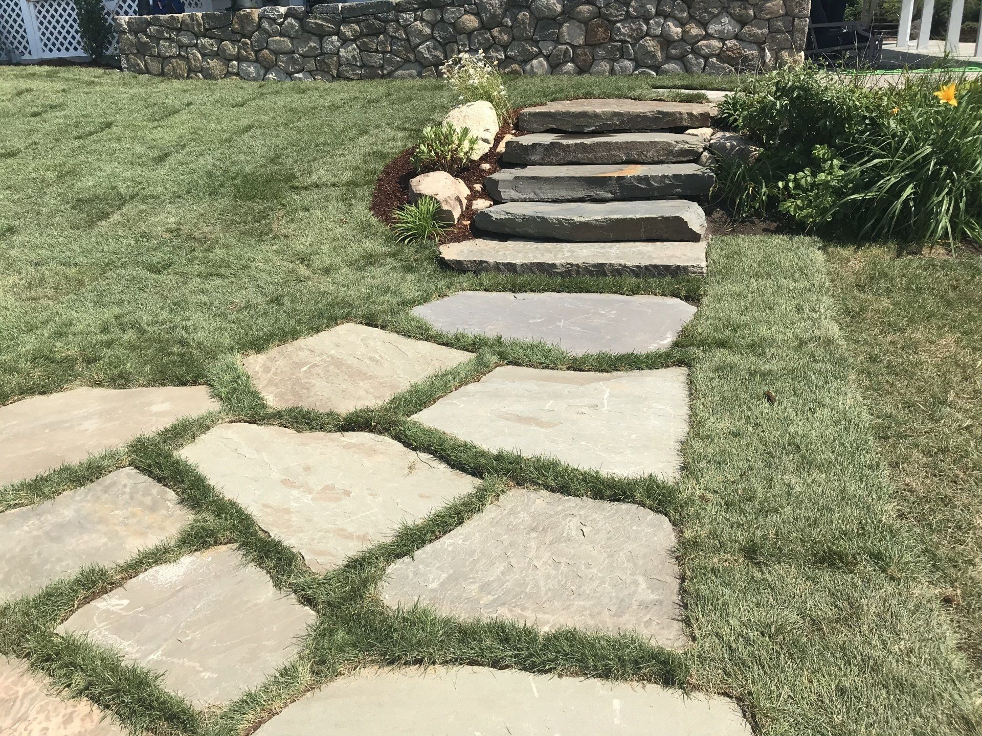 A stone walkway with steps leading up to a house