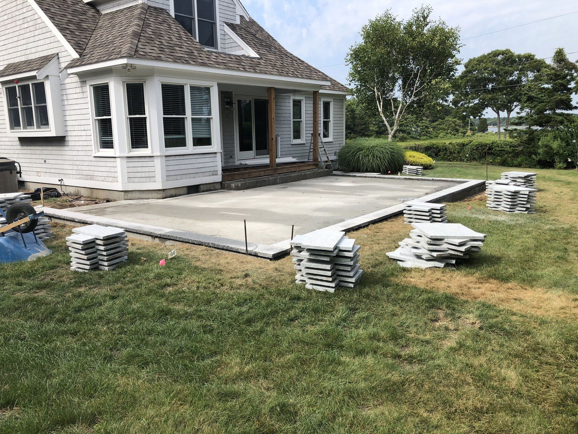 A concrete patio is being built in front of a house