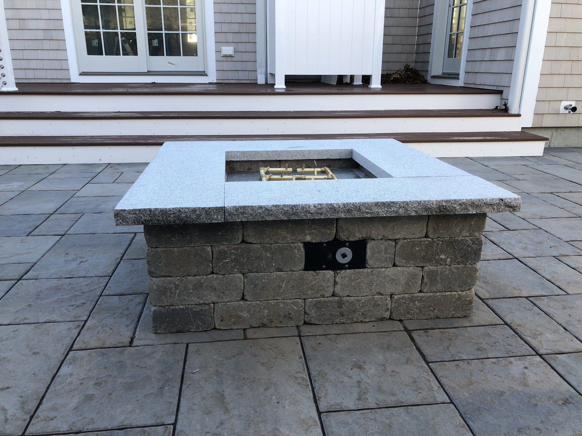 A fire pit is sitting on a patio in front of a house
