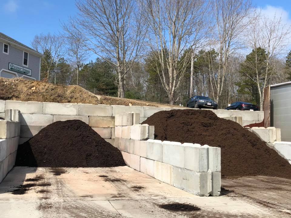 The mulch is contained within concrete block walls, creating a neat and organized space.