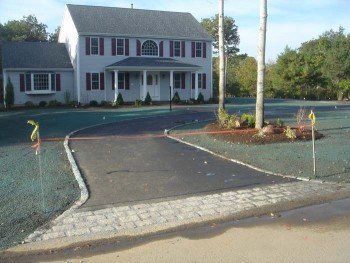 A large white house with a large driveway in front of it