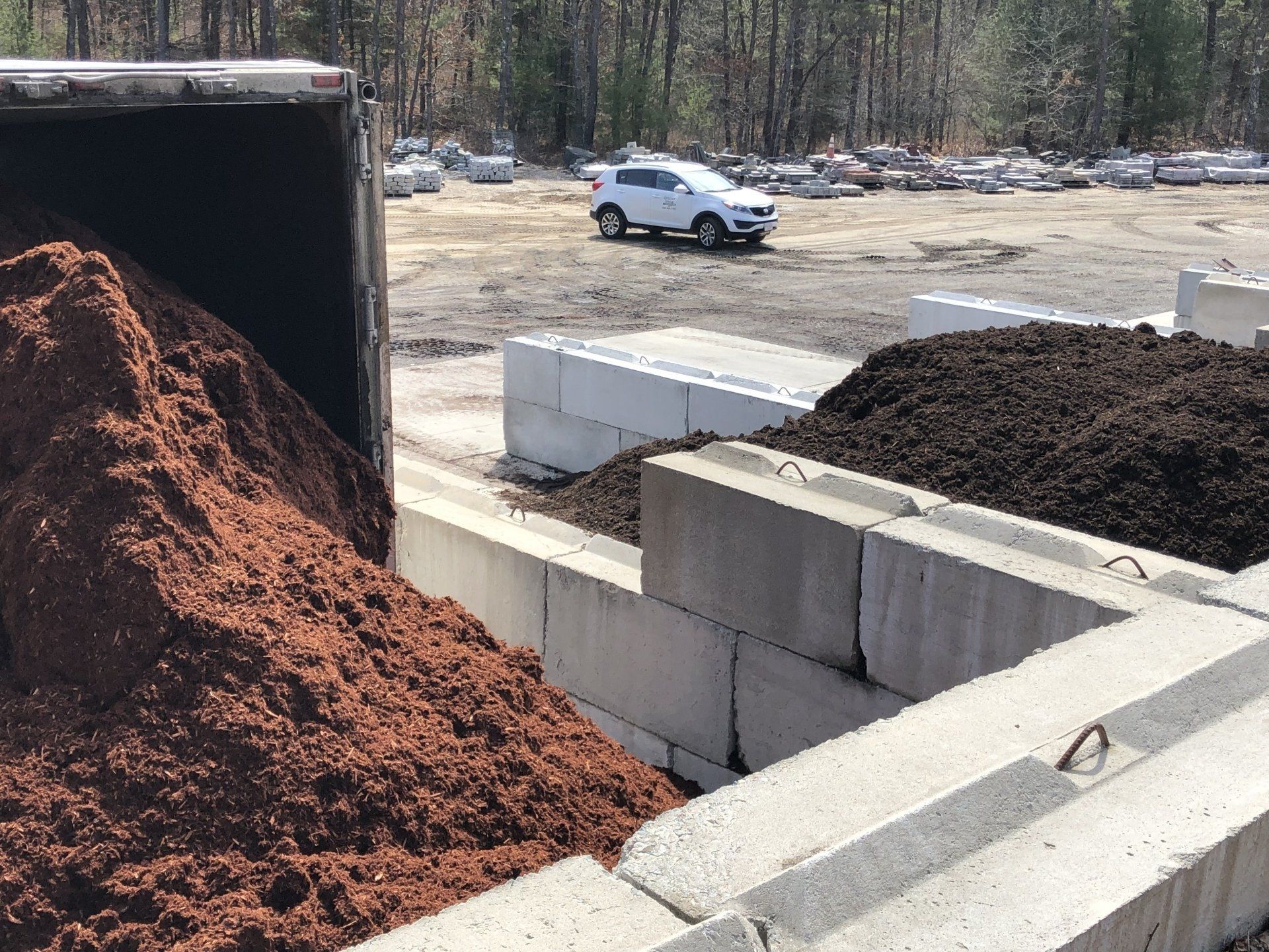 A pile of mulch is being loaded into a truck.