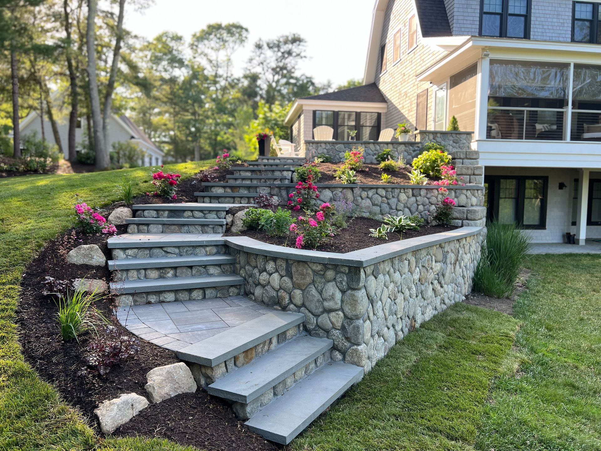 A stone wall with stairs leading up to a house