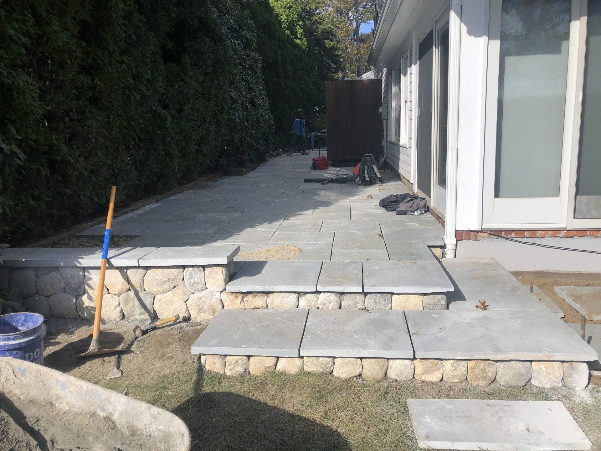 A patio is being built in the backyard of a house.