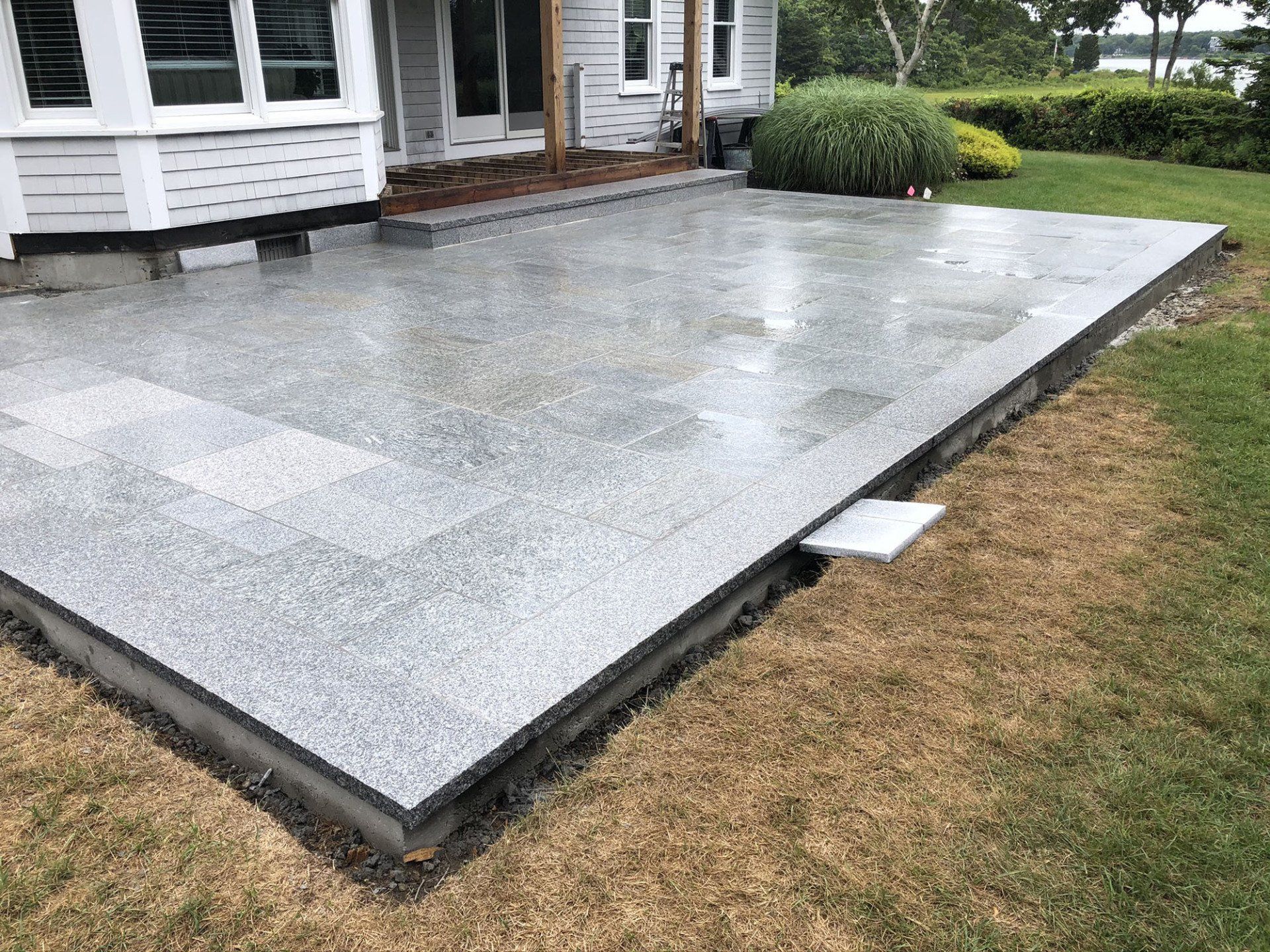 A concrete patio is being built in front of a house.