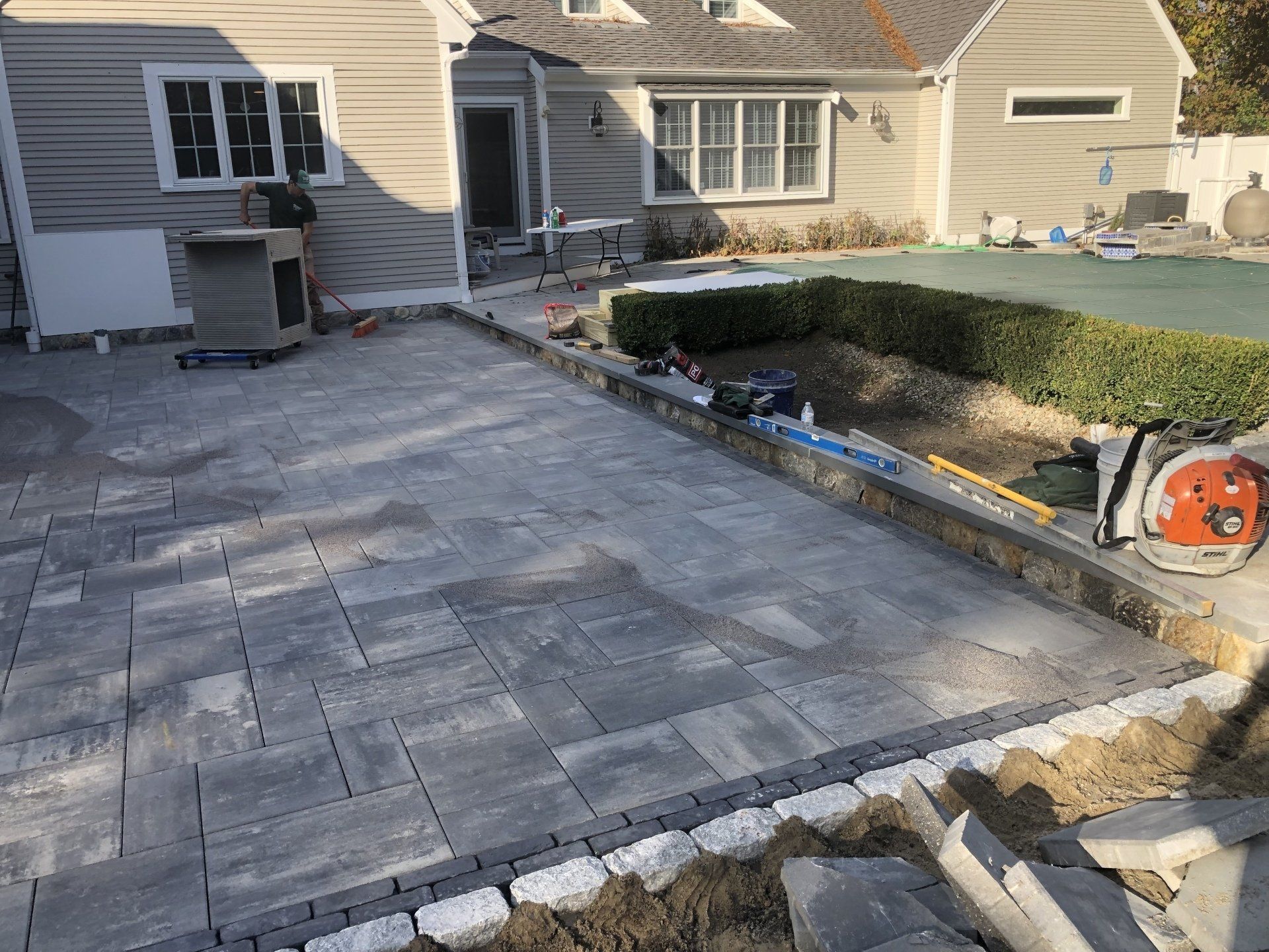A patio is being built in front of a house.