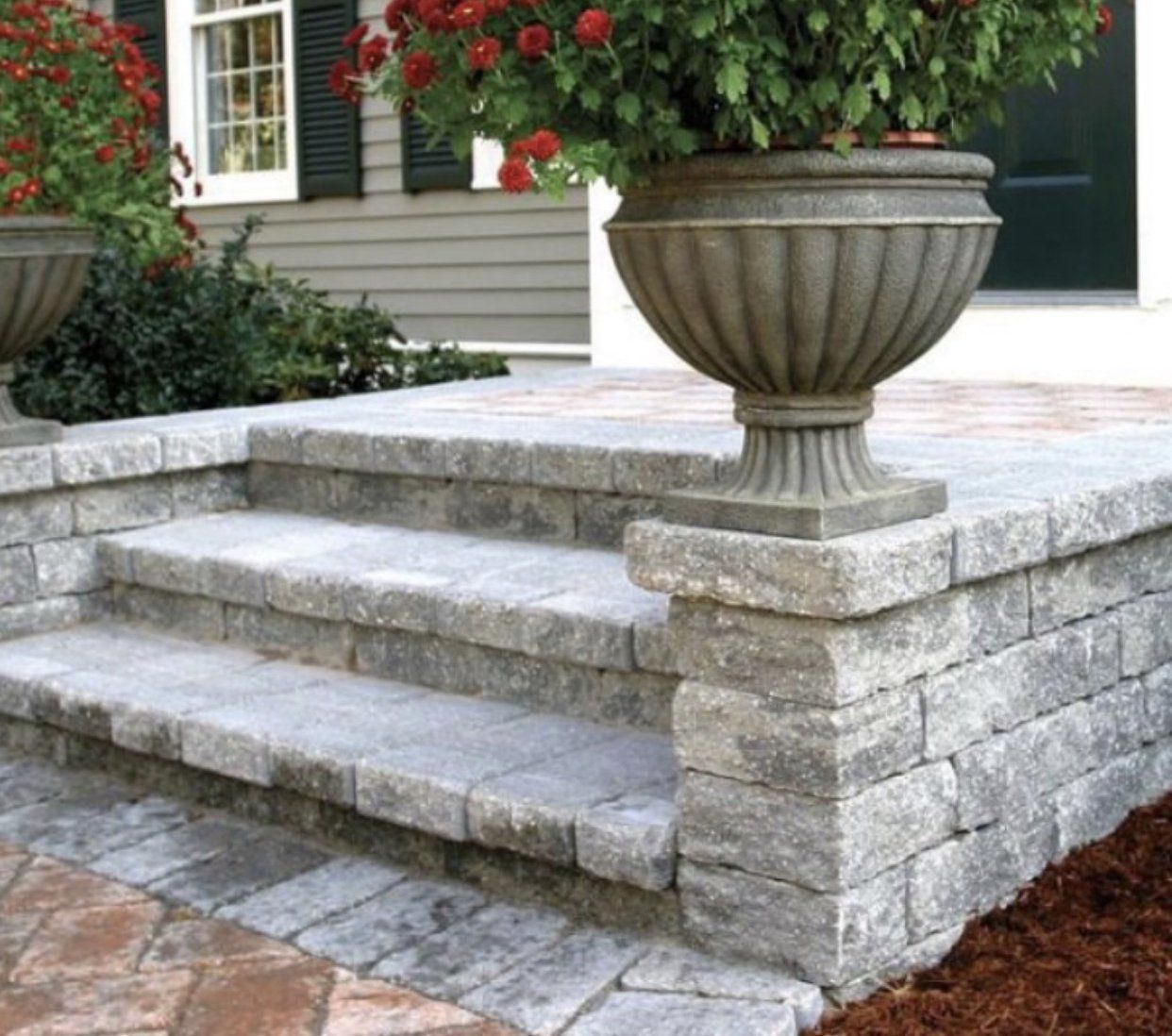 A stone staircase with a planter on top of it.
