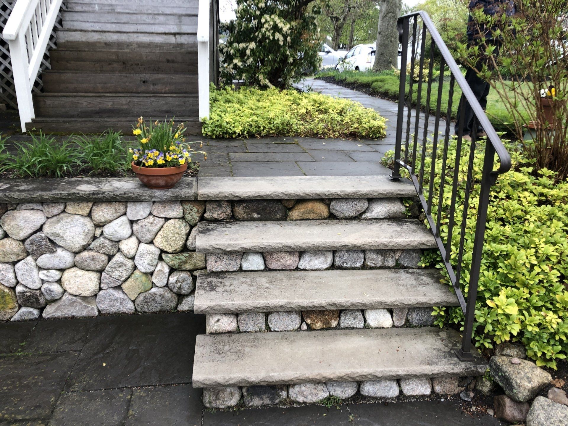 A set of stone steps leading up to a stone wall.