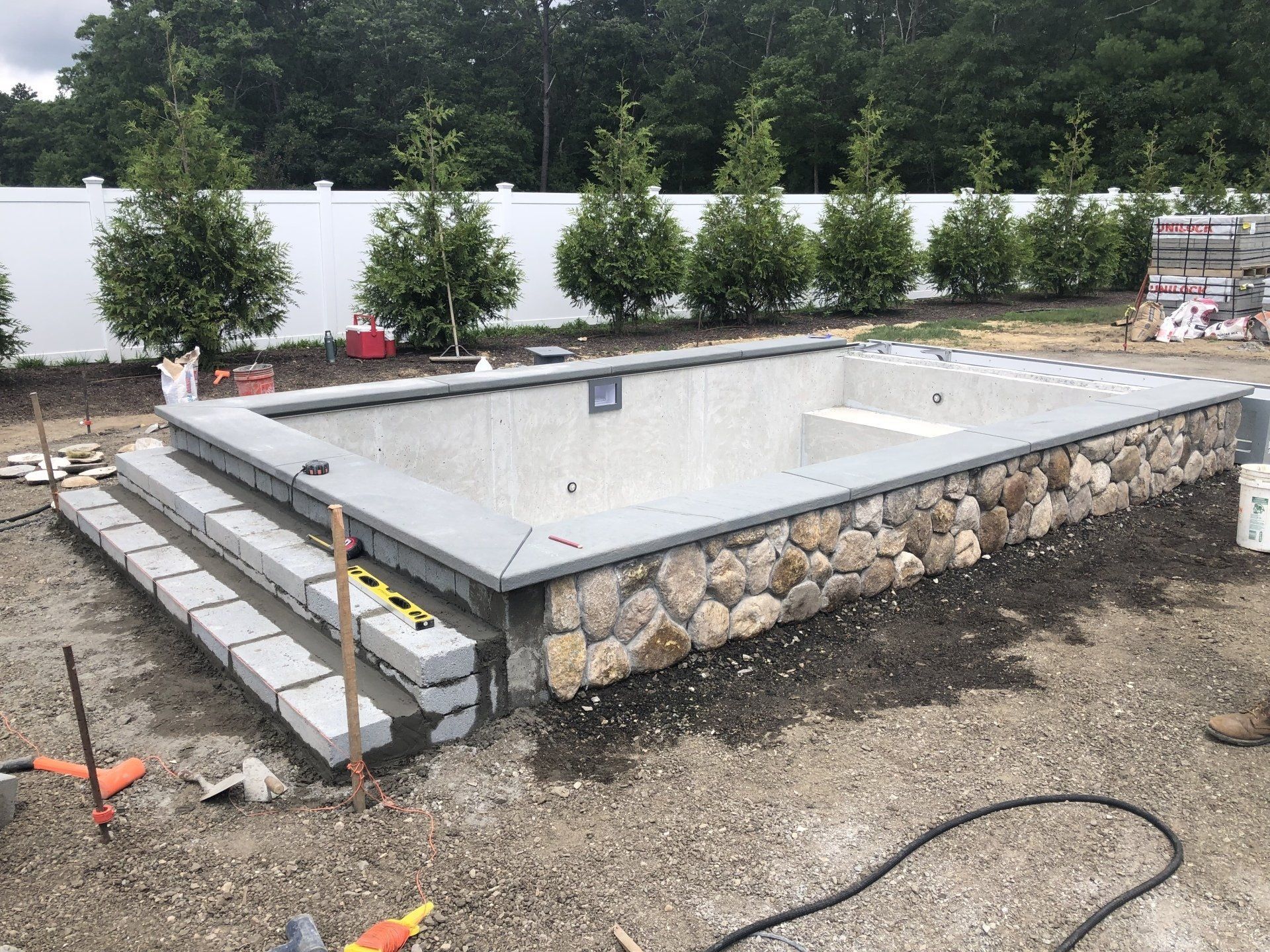 A large swimming pool is being built in a backyard.