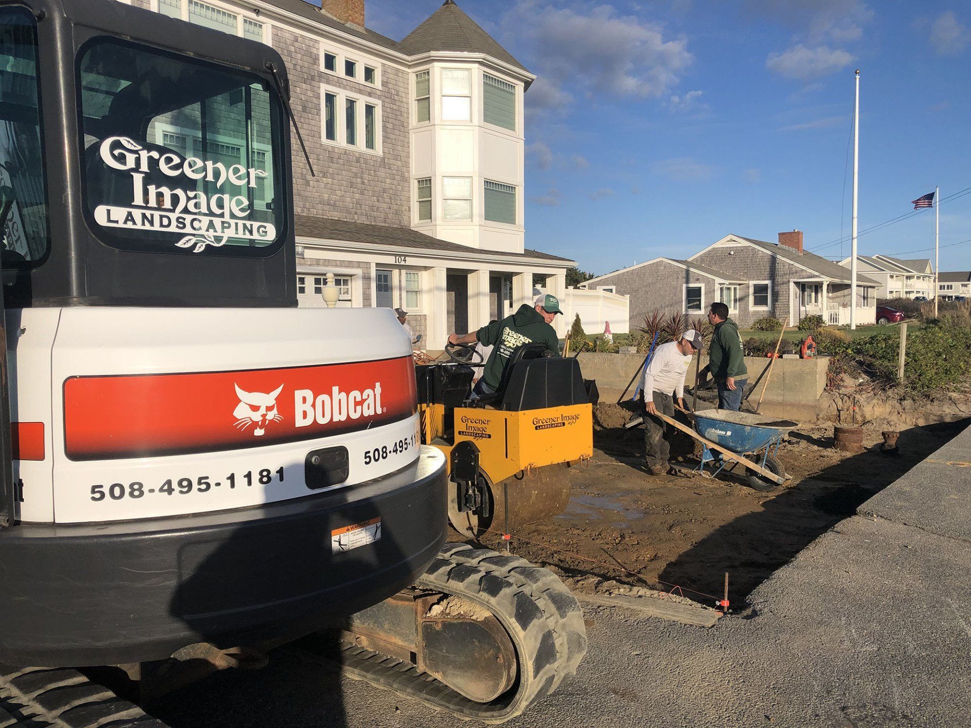 A bobcat truck is parked next to a driveway construction.