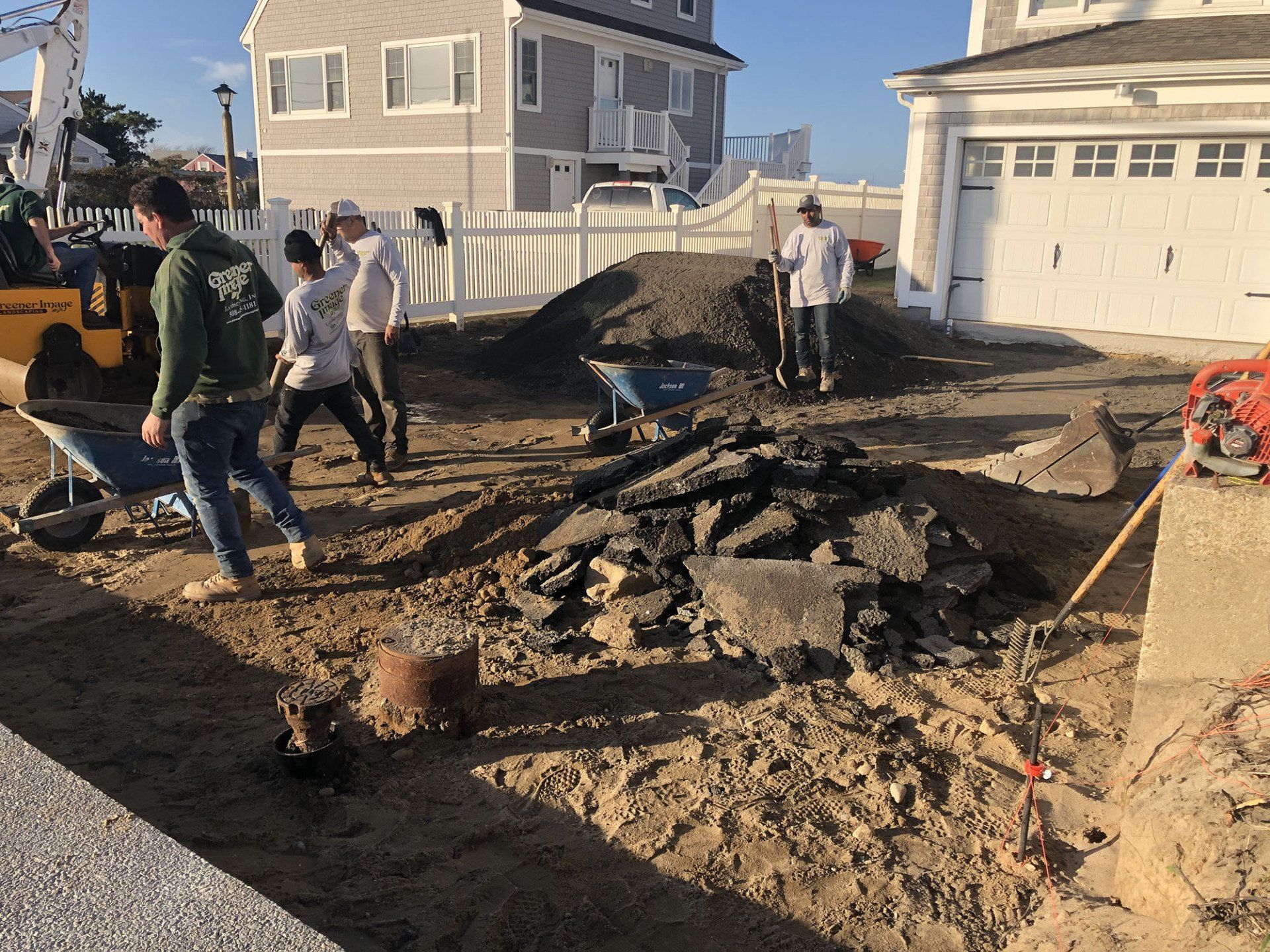 A group of people are working on a residential driveway construction.