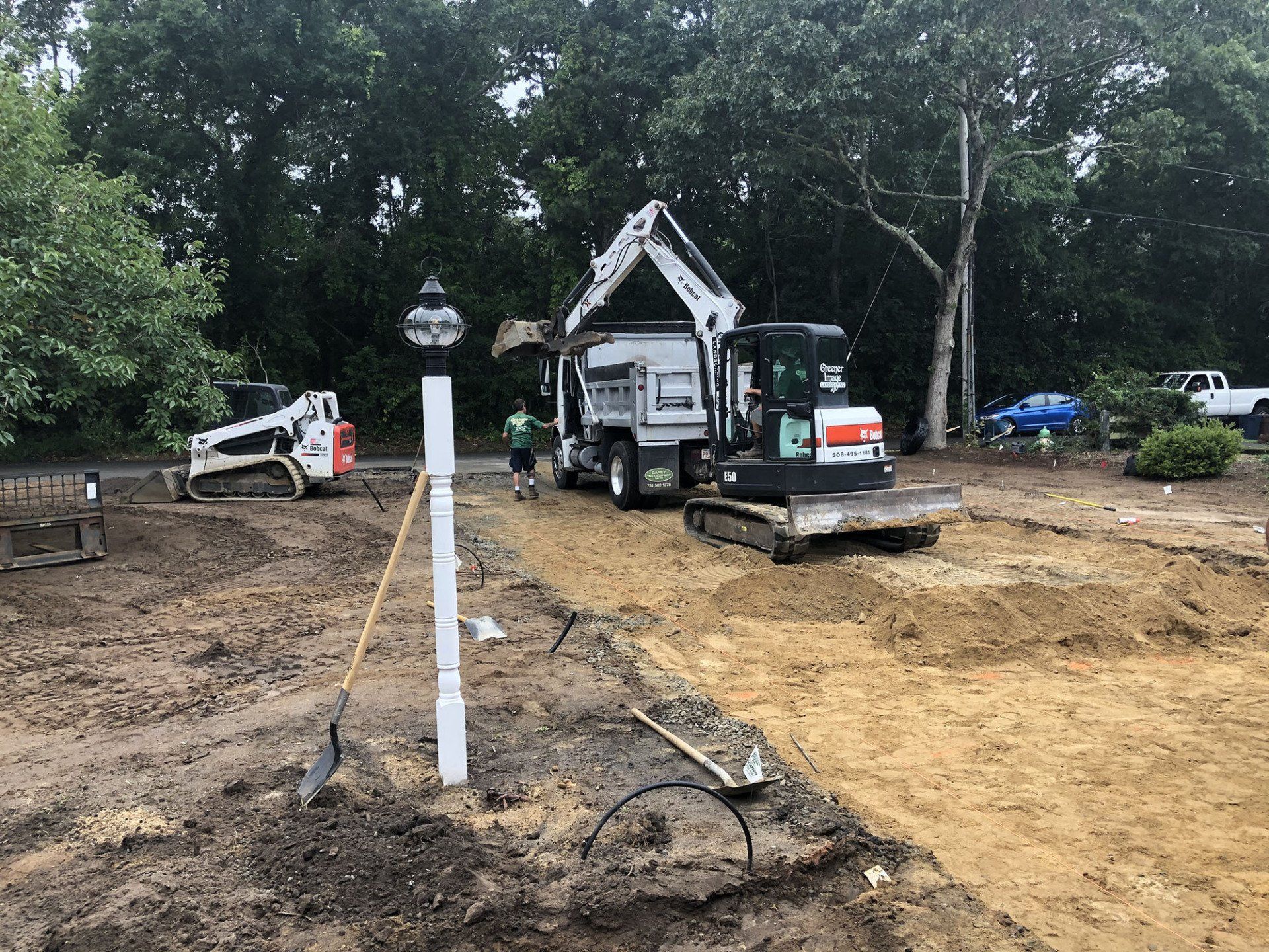 A bulldozer and a dump truck are being used to construct a driveway.