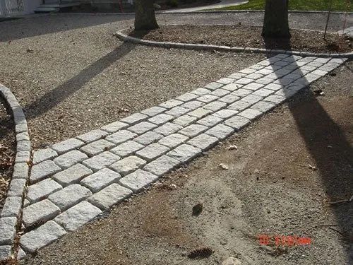 A stone walkway is being built in a park