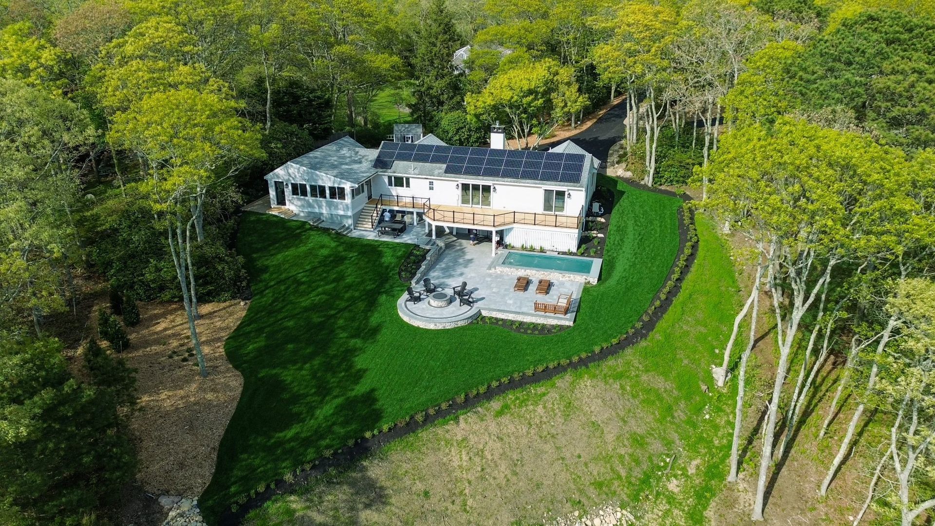 An aerial view of a large house on a hill surrounded by trees