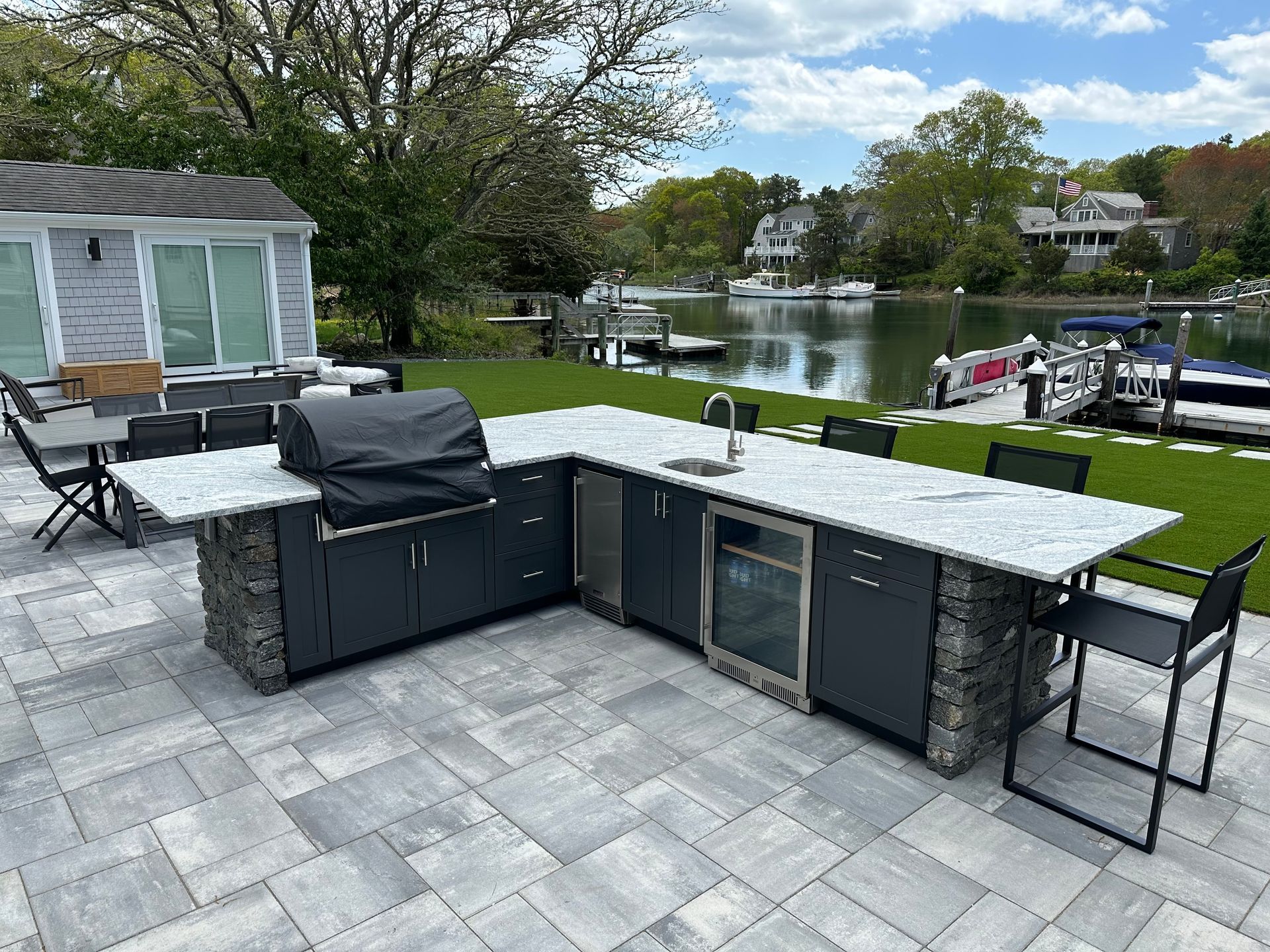There is a large outdoor kitchen with a grill and a sink