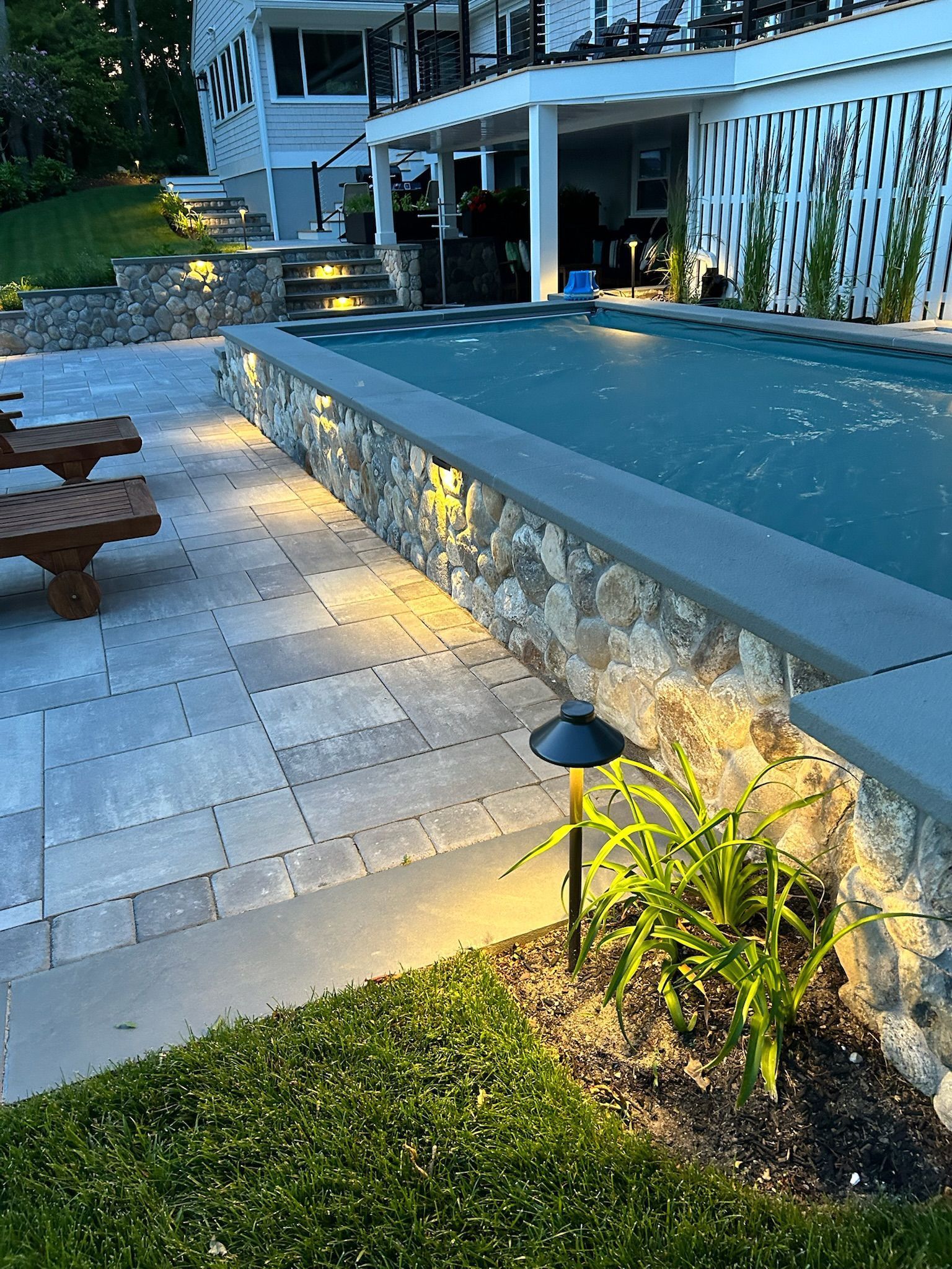 A large swimming pool is surrounded by a stone wall
