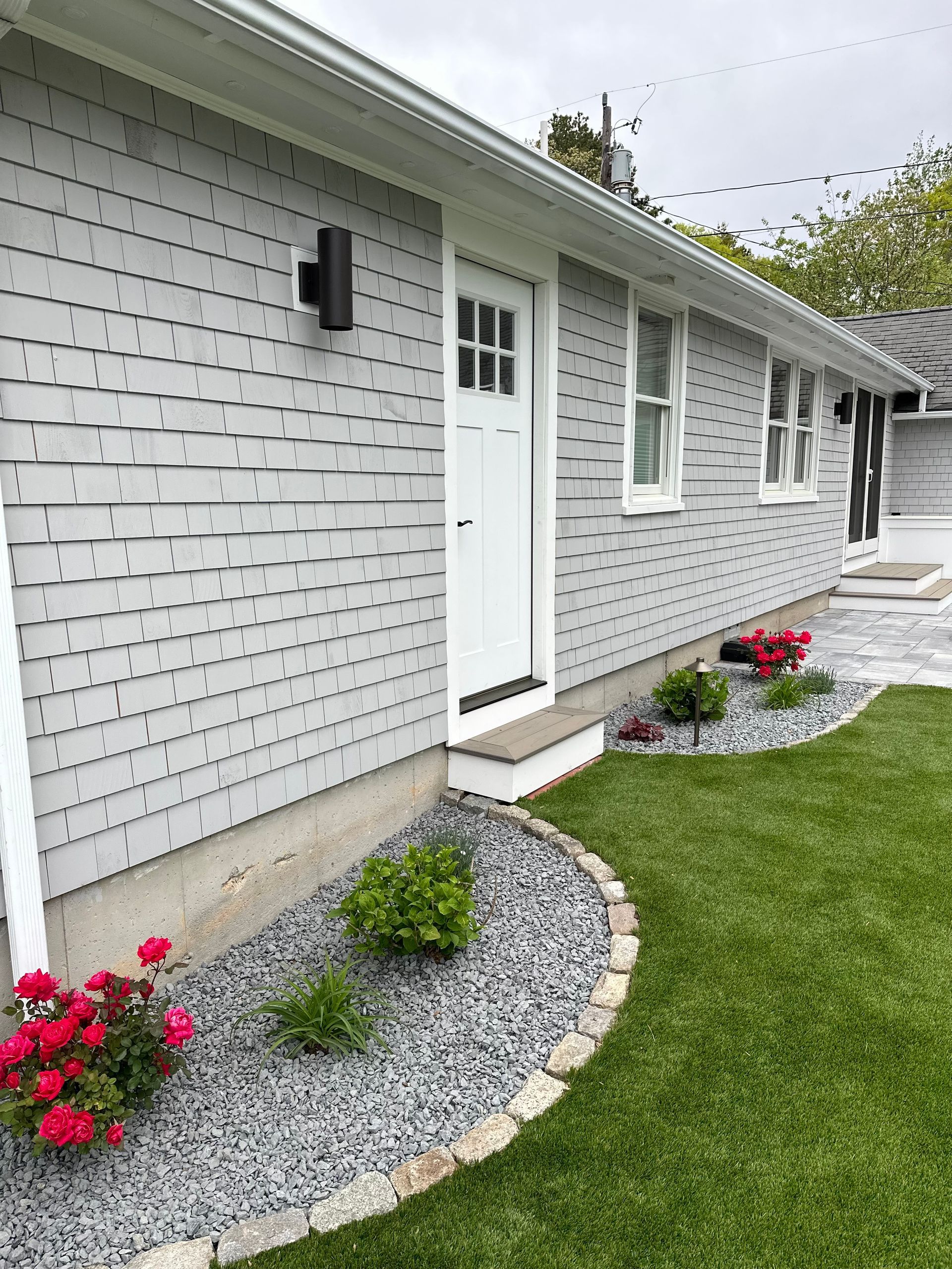 A white house with a white door and a lawn in front of it