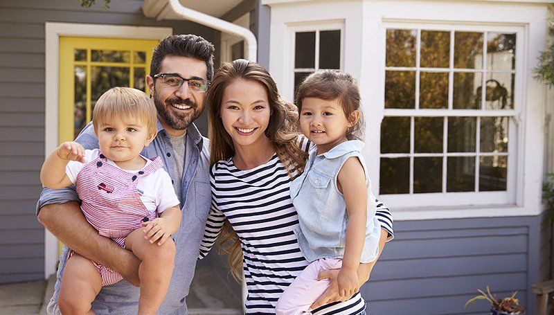 Happy family in front of their house
