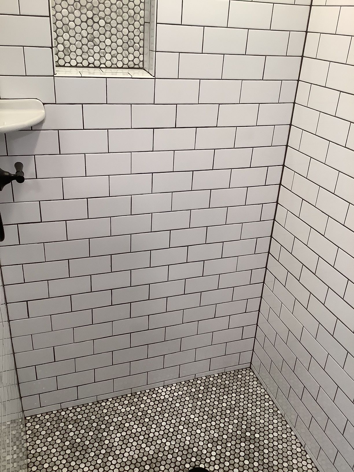A bathroom with white brick walls and a sink