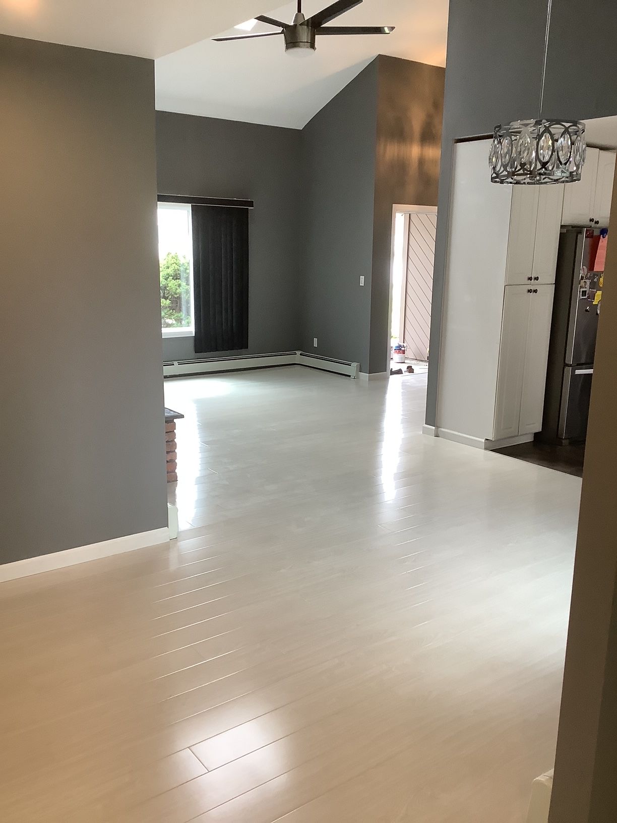 A large empty room with a ceiling fan and a window