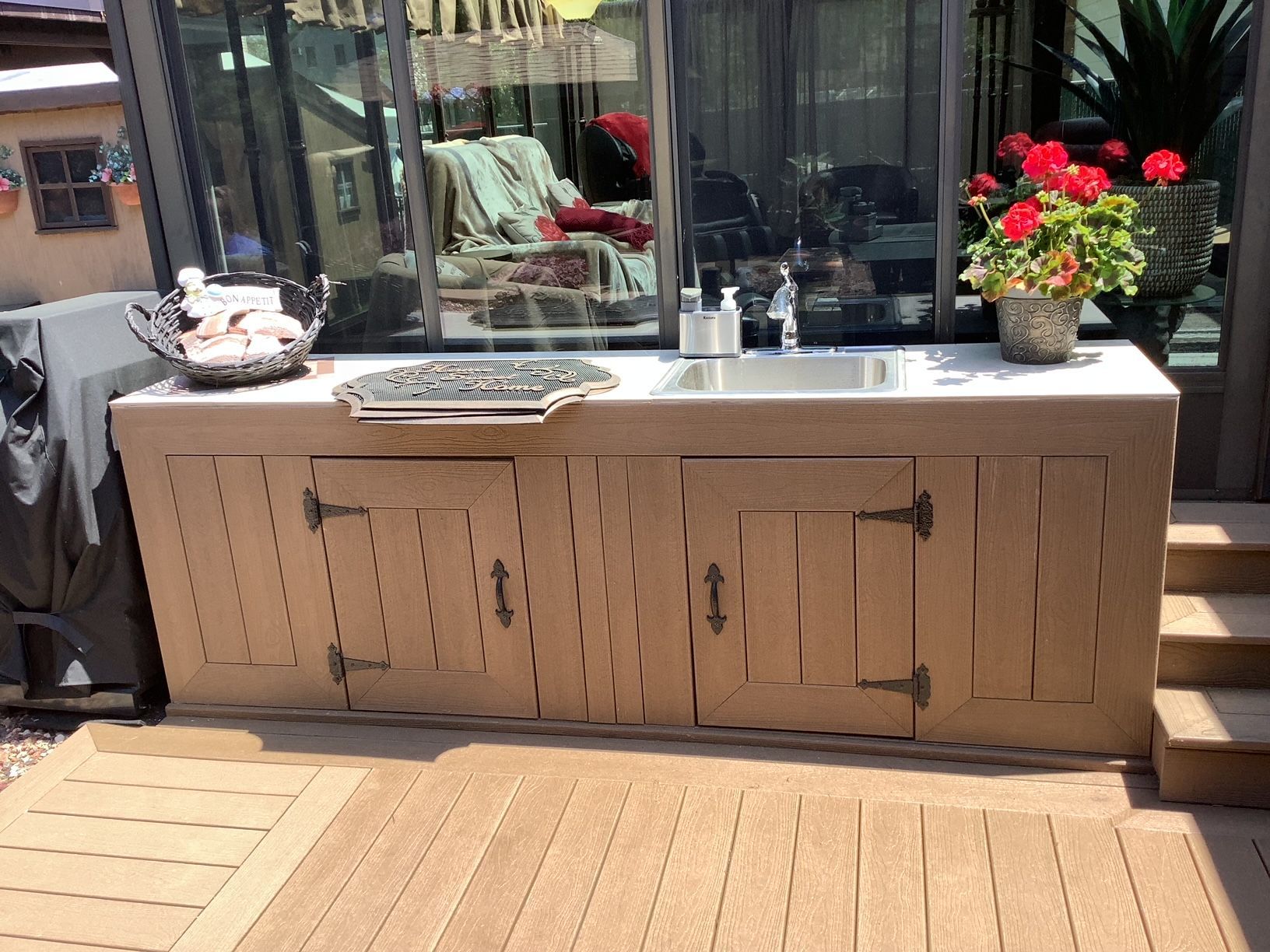 A kitchen with a sink and cabinets on a deck