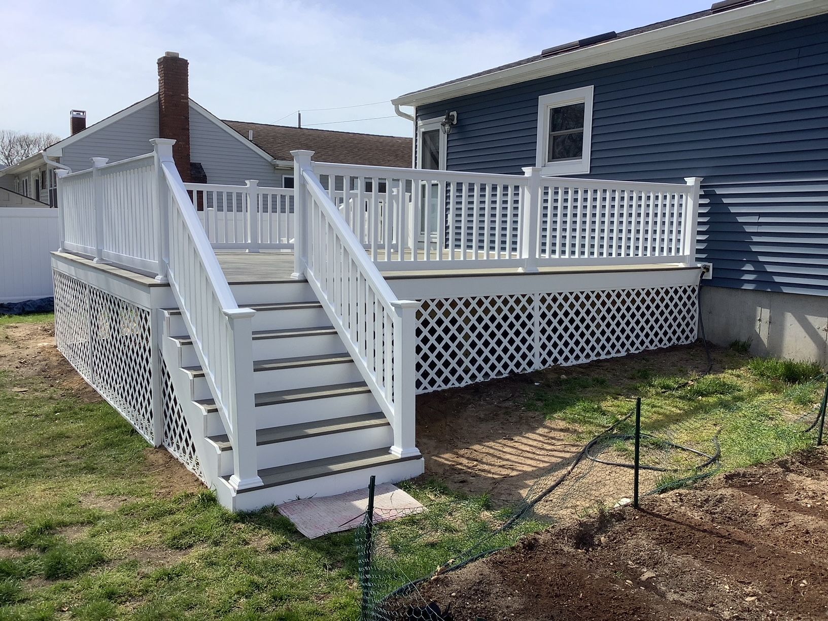 A blue house with a white deck and stairs
