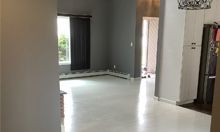 A living room with a white floor and a gray wall