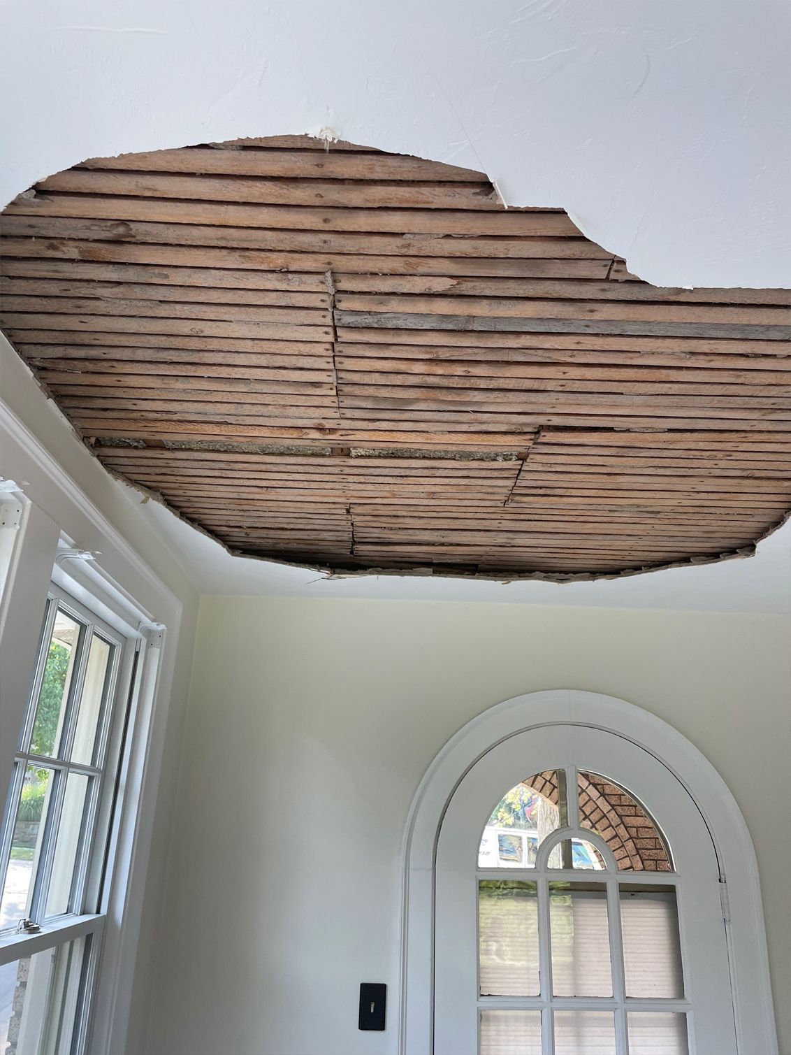 A room with a hole in the ceiling and a window