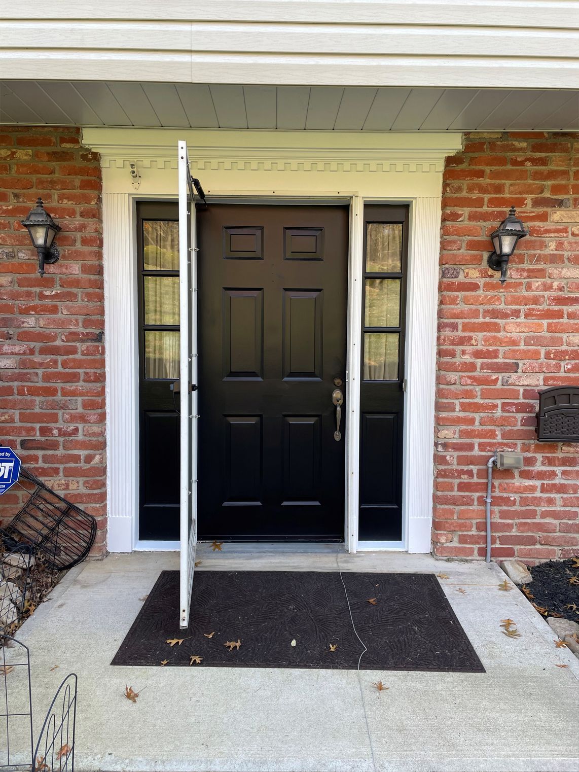 The front door of a brick house with a black door