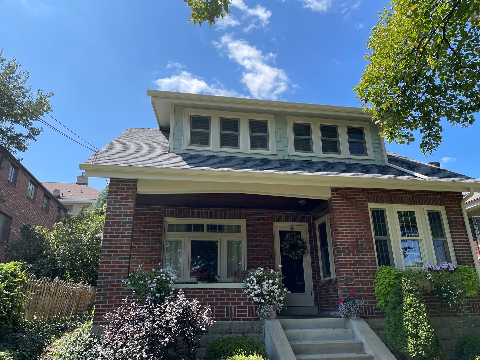 A large brick house with a blue sky in the background.