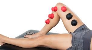 A person is laying on a table with cupping balls on their leg.