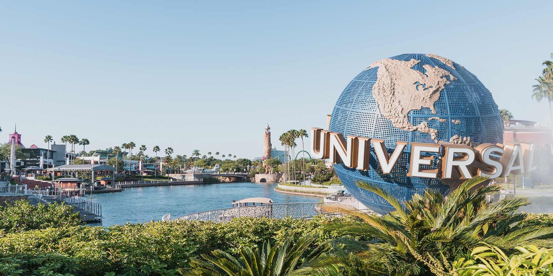A large globe is sitting in front of a sign that says universal studios.