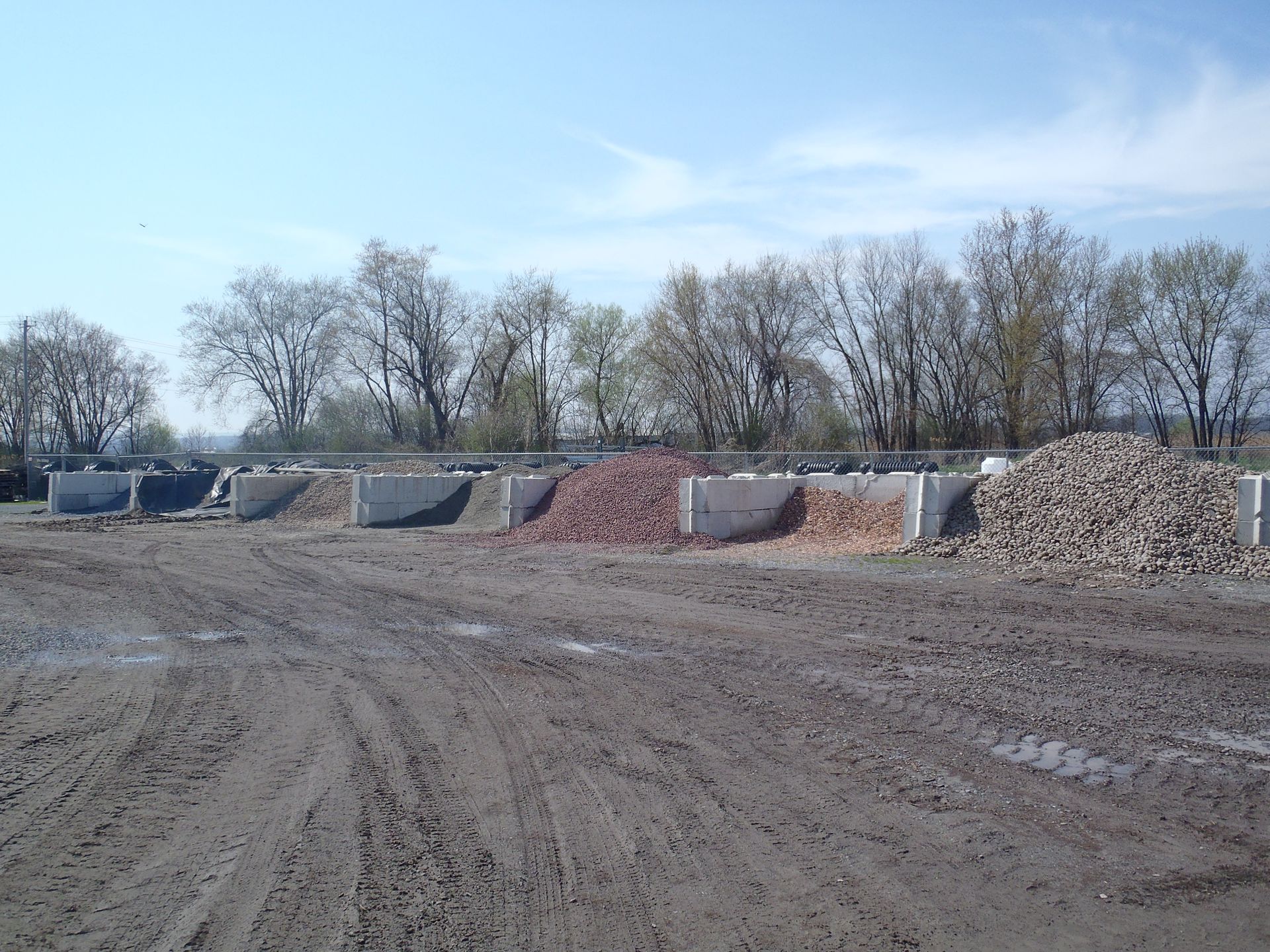 a pile of dirt in a field with trees in the background