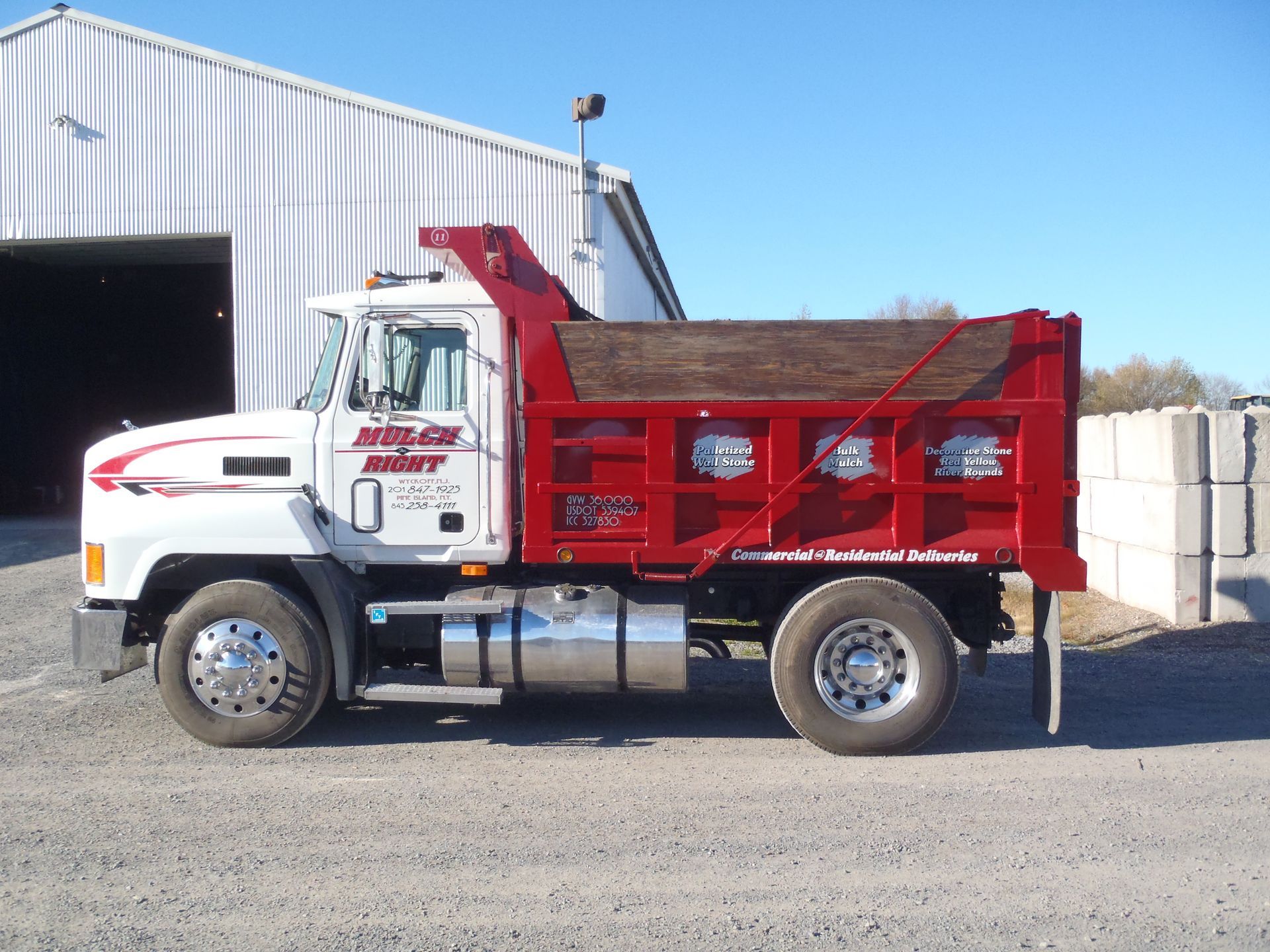 a red and white dump truck is parked in front of a building
